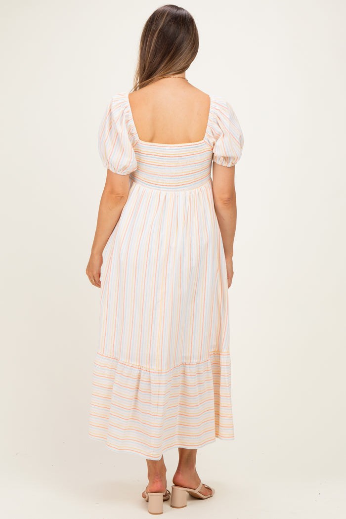 woman wearing a striped maternity maxi dress with puff sleeves and a smocked bodice, showing her back