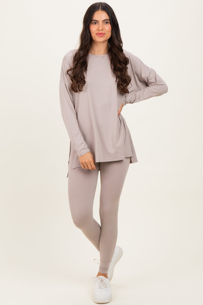 woman wearing a taupe long sleeve top and matching leggings, standing with one leg slightly forward and casual sneakers