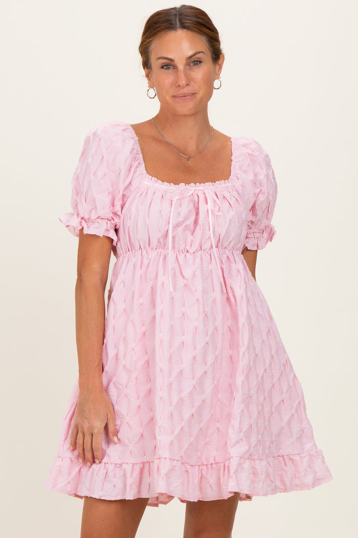 woman wearing a pink puff sleeve dress with a square neckline and ruffled hem