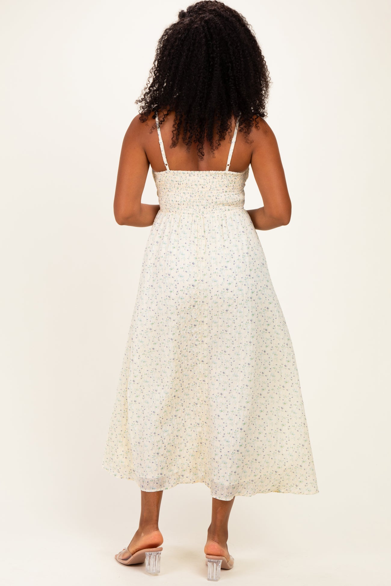 woman wearing a back view of a floral print midi dress with smocked bodice and thin straps