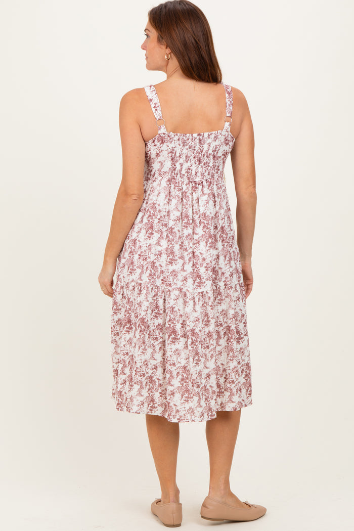 woman wearing a back view of a pink and white floral midi dress with adjustable straps and smocked bodice