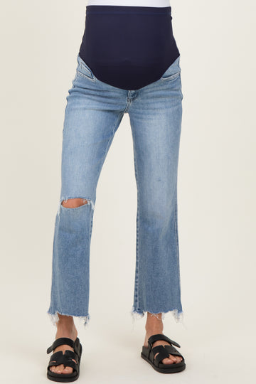 woman wearing a pair of distressed light blue maternity jeans with a dark blue over-the-bump waistband