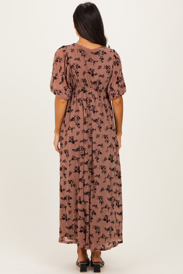 woman wearing a brown floral maxi dress with short puff sleeves, shown from the back