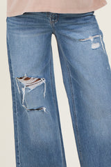 woman wearing a pair of distressed maternity jeans with wide legs and ripped details