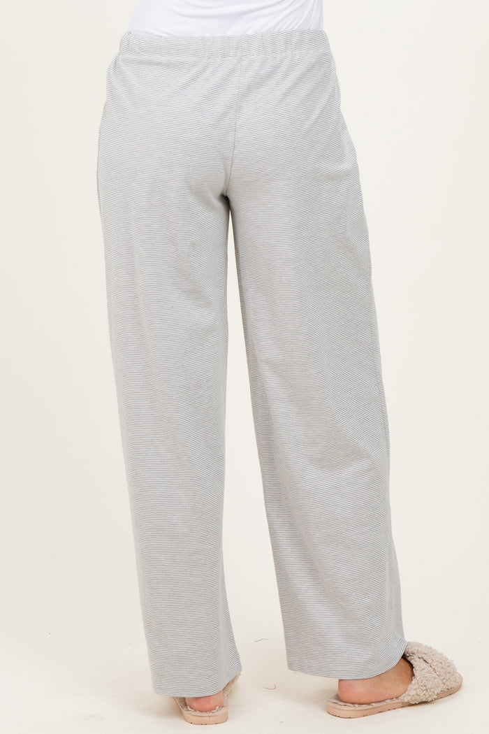woman wearing light gray wide-leg lounge pants, view from the back, paired with cozy slippers