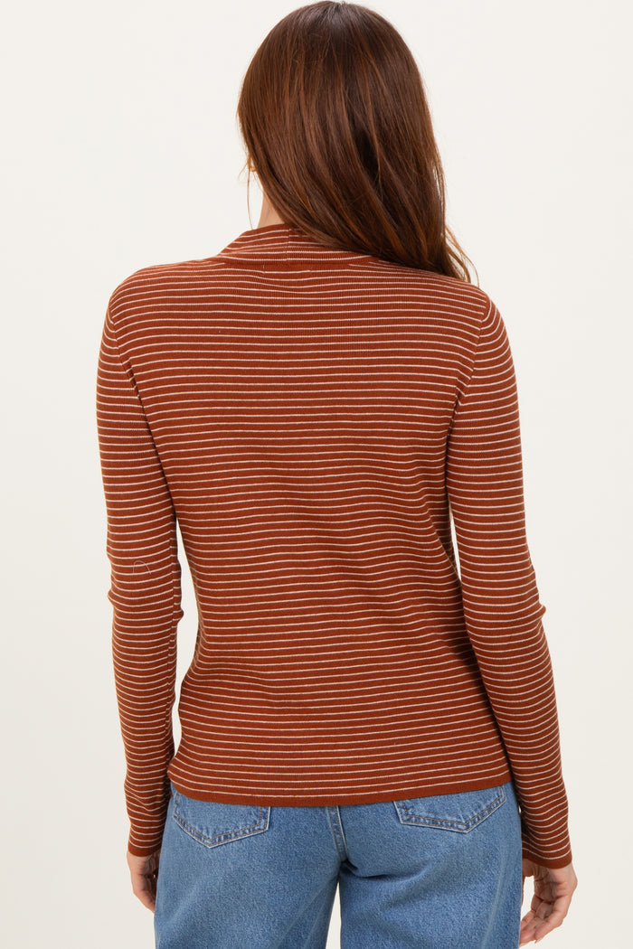 woman wearing a rust striped long sleeve top, seen from the back
