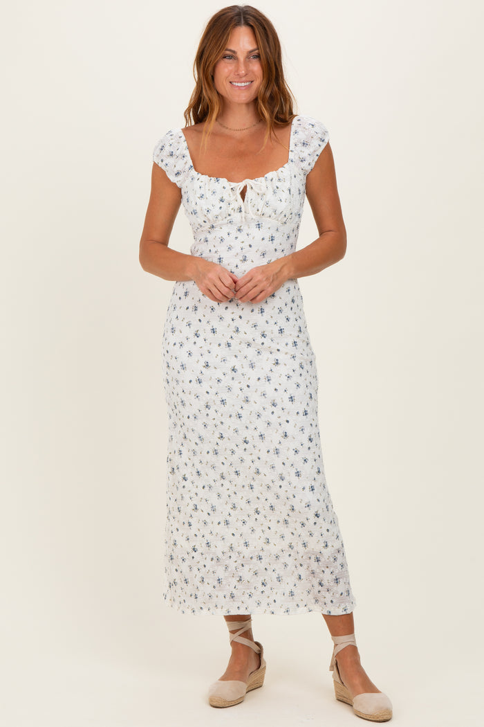 woman wearing a white floral midi dress with short puff sleeves and a front tie detail