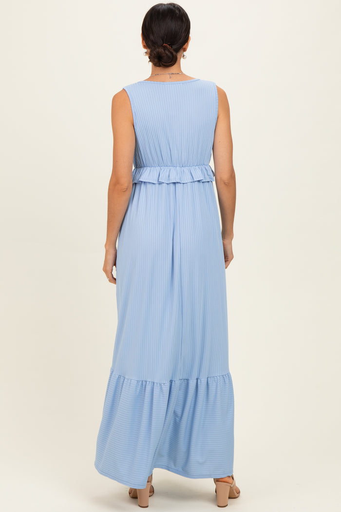 woman wearing a light blue sleeveless maxi dress with a ruffled waist and tiered skirt, viewed from the back