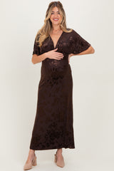 woman wearing a dark brown floral print maternity maxi dress and holding her baby bump