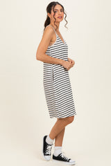 woman wearing a black and white striped sleeveless dress with a loose fit and sneakers