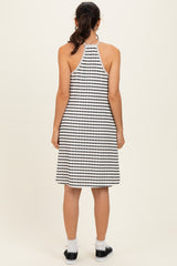woman wearing a black and white striped halter dress, showing the back view with a relaxed fit and casual style