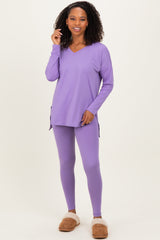 woman wearing a purple long sleeve v-neck top and matching leggings, paired with cozy slippers