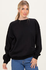 woman wearing a black oversized sweatshirt and blue jeans with a relaxed fit