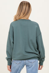 woman wearing a green oversized maternity sweatshirt, viewed from the back with relaxed fit and dropped shoulders