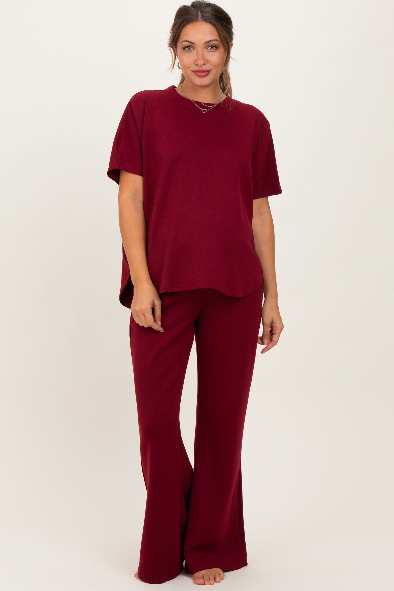 woman wearing a burgundy maternity top with short sleeves and matching wide-leg pants