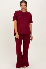 woman wearing a burgundy maternity top with short sleeves and matching wide-leg pants