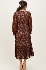 woman wearing a brown lace maternity dress with long sleeves and a flowing silhouette, shown from the back