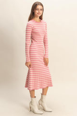 woman wearing a pink and white striped long sleeve fitted dress with a flared hem and ankle boots