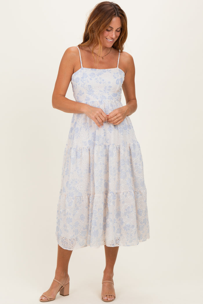 woman wearing a light blue floral tiered midi dress with spaghetti straps and a relaxed fit