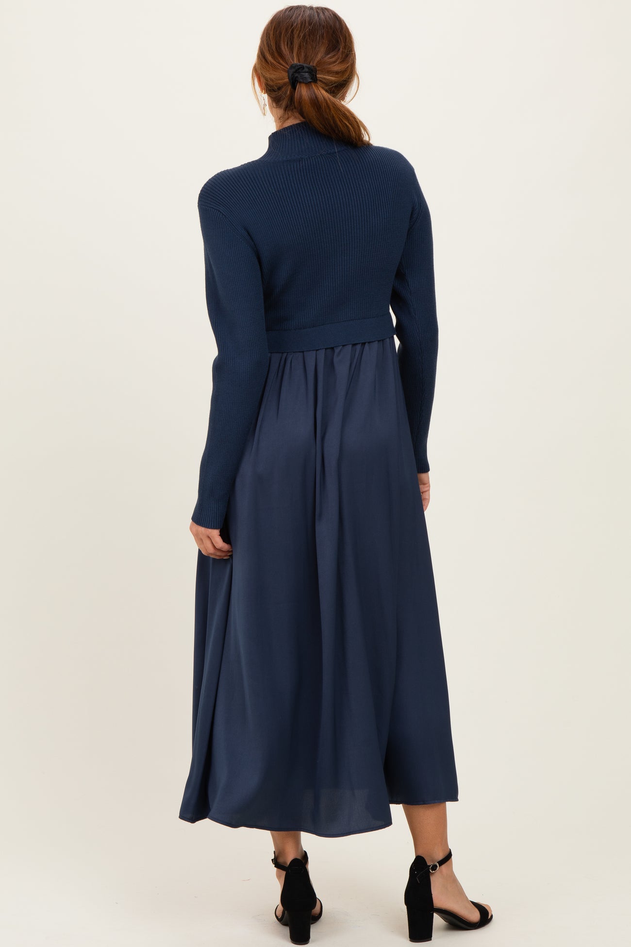 woman wearing a navy blue long sleeve sweater top paired with a flowing navy blue midi skirt