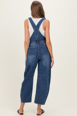 woman wearing a pair of blue denim maternity overalls with wide legs, seen from the back