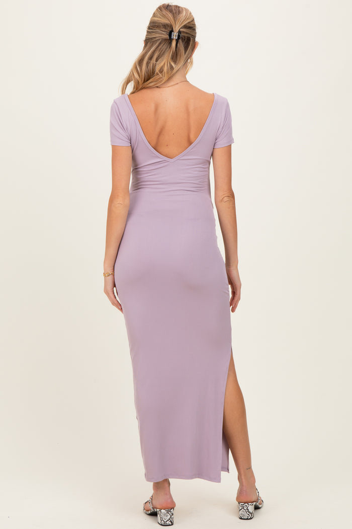 woman wearing a lavender maternity maxi dress with a deep back neckline and side slit