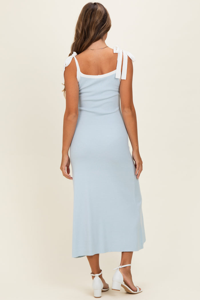 woman wearing a light blue ribbed maxi dress with white tie straps, viewed from the back