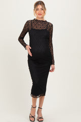 woman wearing a black lace long sleeve maternity dress that hugs her baby bump