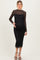woman wearing a black lace long sleeve maternity dress that hugs her baby bump