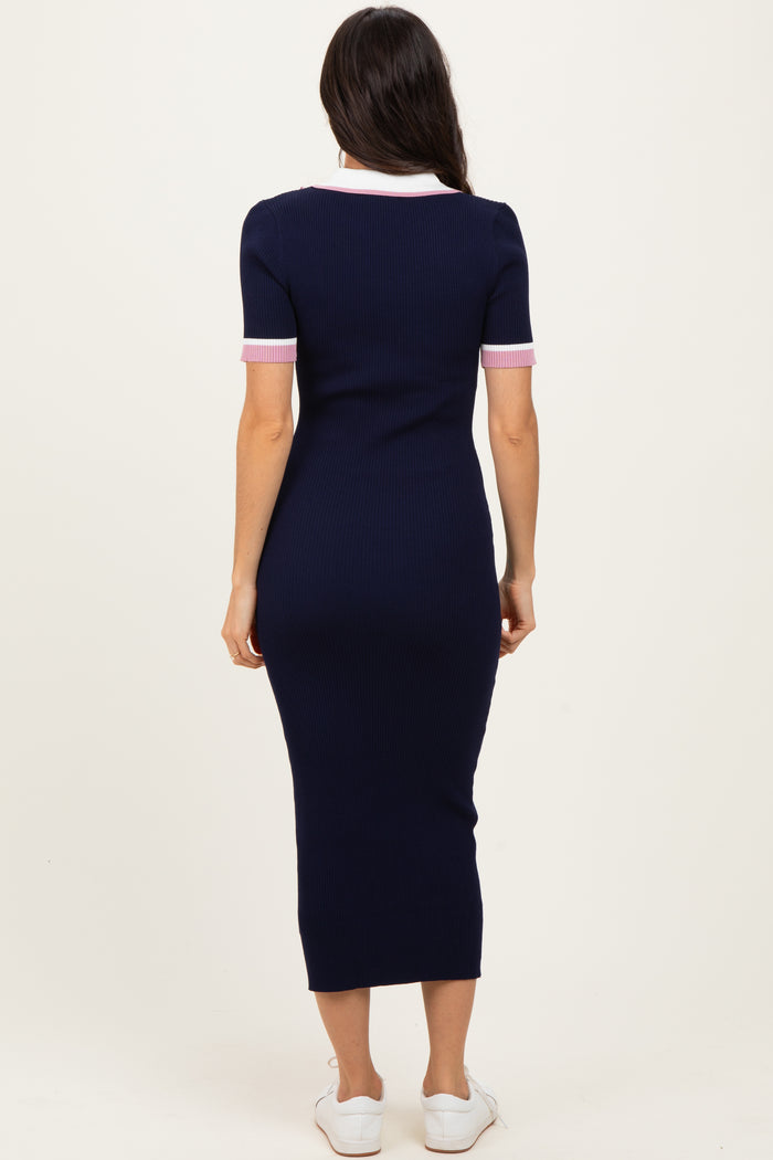 woman wearing a navy ribbed midi dress with pink striped short sleeves and a white collar, viewed from the back