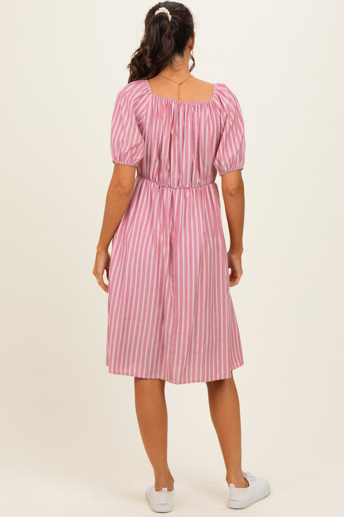woman wearing a pink and white striped short sleeve dress with a cinched waist and a midi length