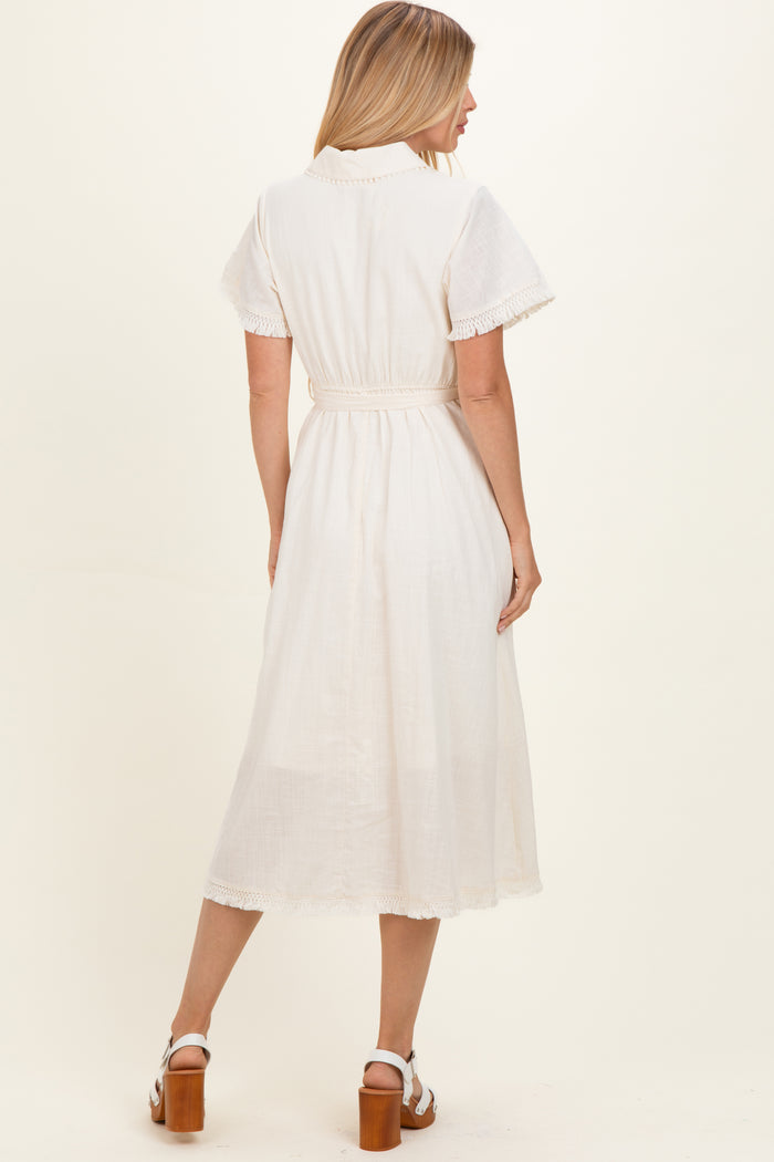 woman wearing a white midi dress with short sleeves and a belted waist, shown from the back