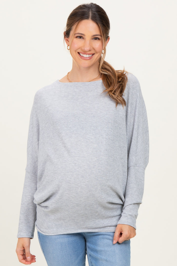 woman wearing a light gray long sleeve maternity top with a relaxed fit and gathered detail, smiling at the camera