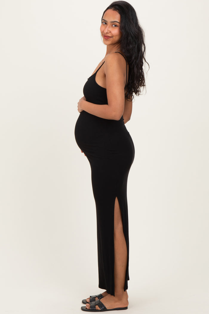 woman wearing a black ribbed maternity dress with side slits and holding her baby bump