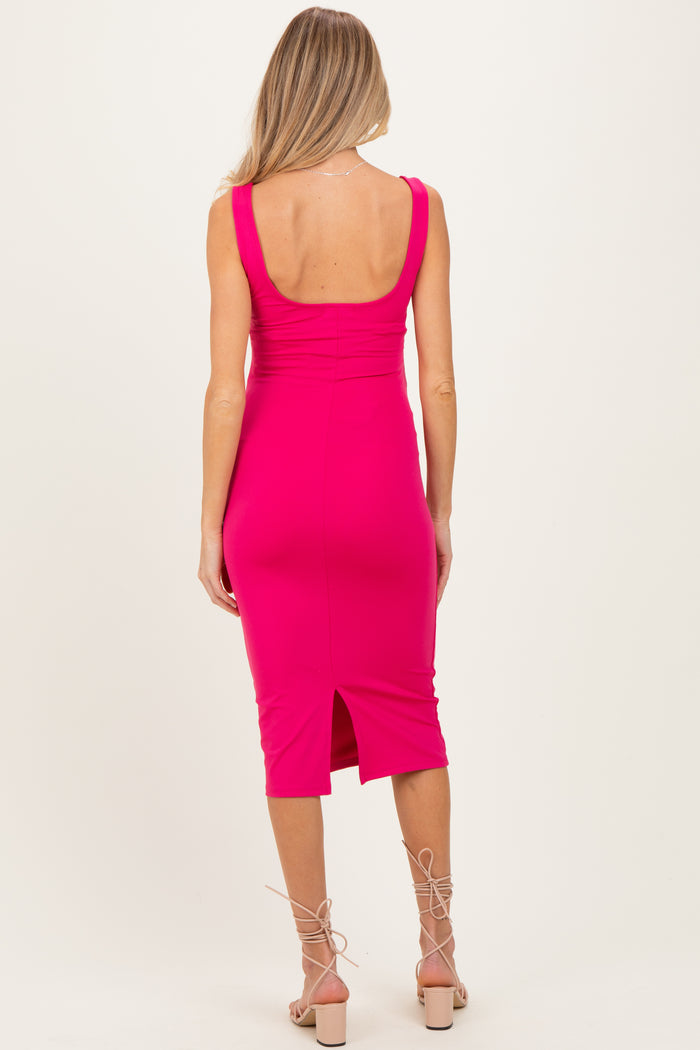 woman wearing a hot pink sleeveless maternity dress with a back slit and a fitted silhouette