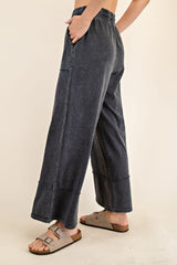 woman wearing dark gray wide-leg denim pants with an elastic waistband and side pockets