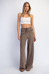 woman wearing a white cropped tank top and loose taupe knit wide-leg pants with front pockets