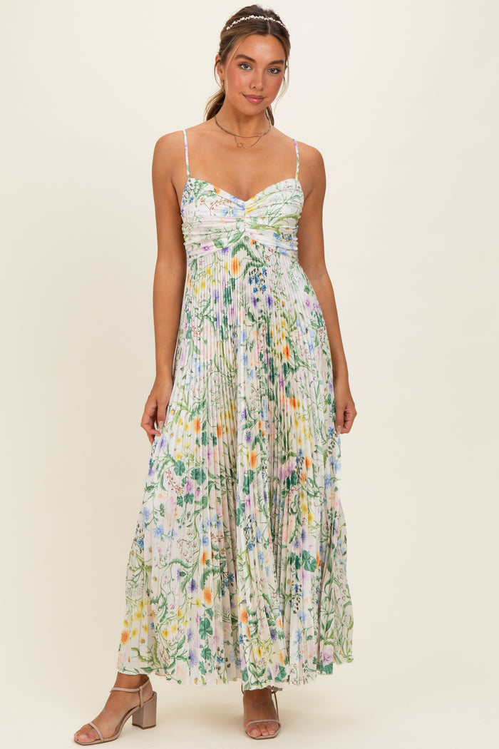 woman wearing a floral maxi dress with a knotted front and spaghetti straps, standing against a light background