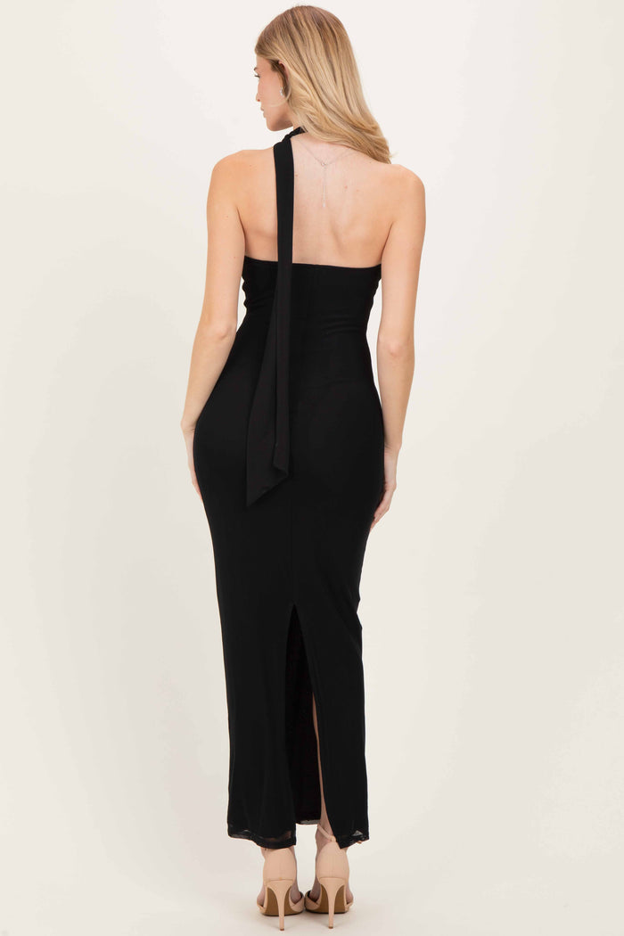 woman wearing a black halter neck maxi dress with a back tie detail and side slit