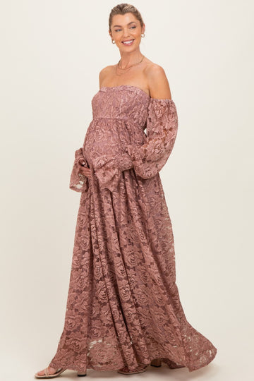 woman wearing a dusty rose off-shoulder lace maternity maxi dress with long puff sleeves and a visible baby bump