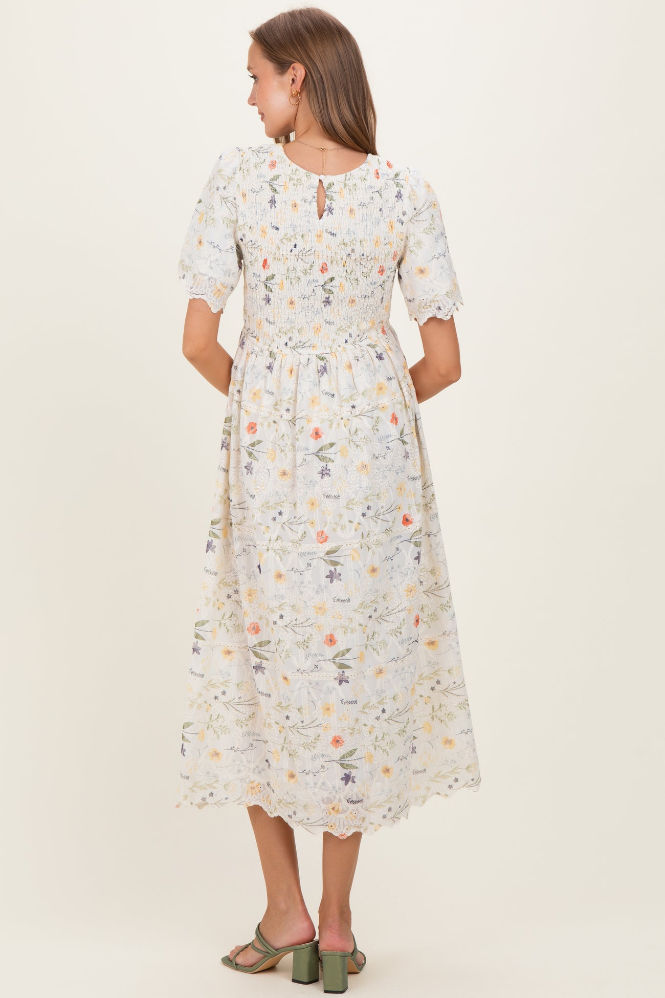 woman wearing a floral print maternity dress with short puff sleeves and a smocked back detail