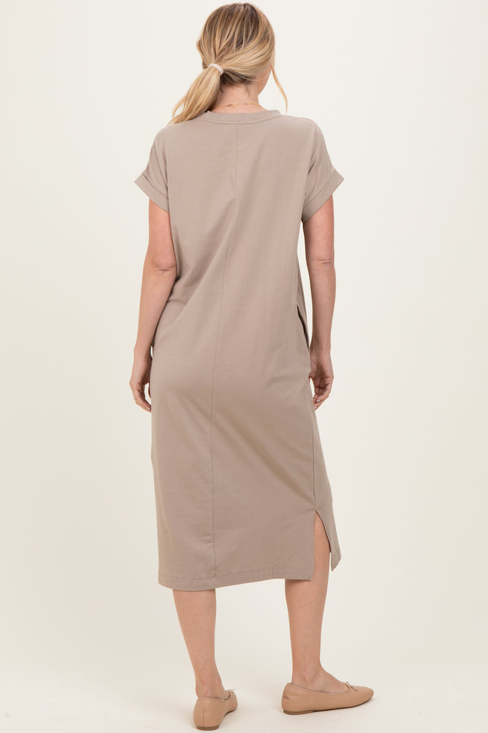 woman wearing a taupe short sleeve midi dress with side slits and a relaxed fit, viewed from the back