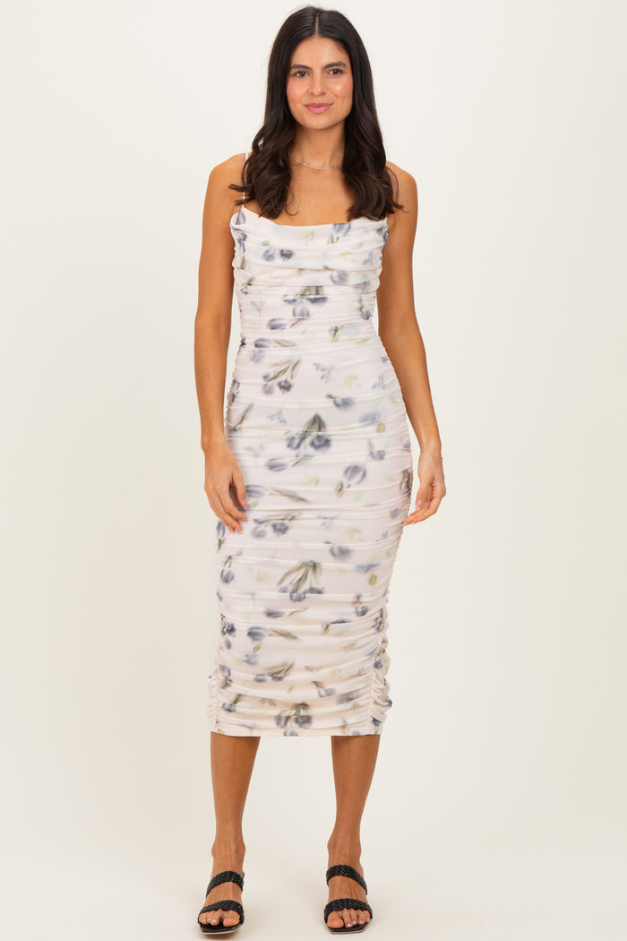 woman wearing a fitted white midi dress with floral prints and ruching details