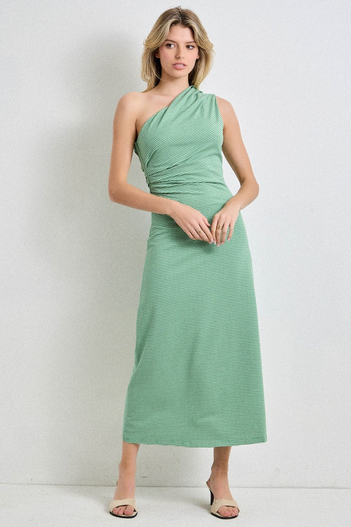woman wearing a green one-shoulder maxi dress with a fitted bodice and flowing skirt