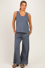 woman wearing a blue maternity tank top and wide-leg pants, styled for comfort during pregnancy