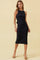 woman wearing a black ribbed midi dress with a sleek fit and side slit, paired with tan high-heeled sandals