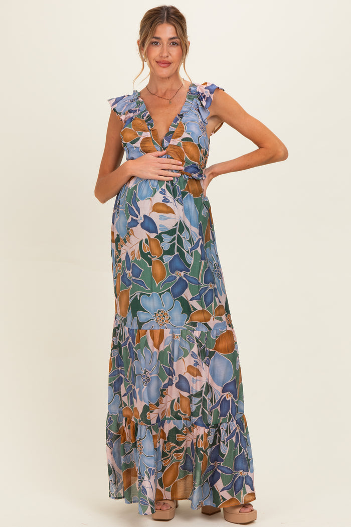 woman wearing a floral maternity maxi dress with ruffled sleeves and holding her baby bump