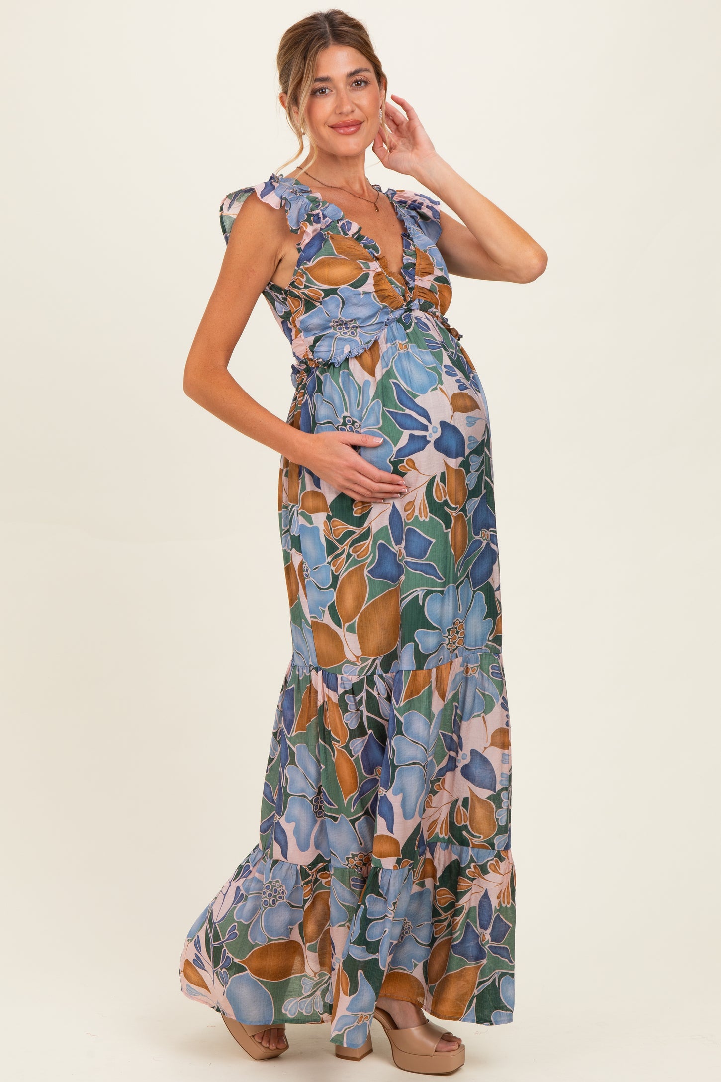 woman wearing a floral print maternity maxi dress with ruffled sleeves and a visible baby bump