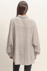 woman wearing a black and white striped oversized shirt with balloon sleeves, viewed from the back