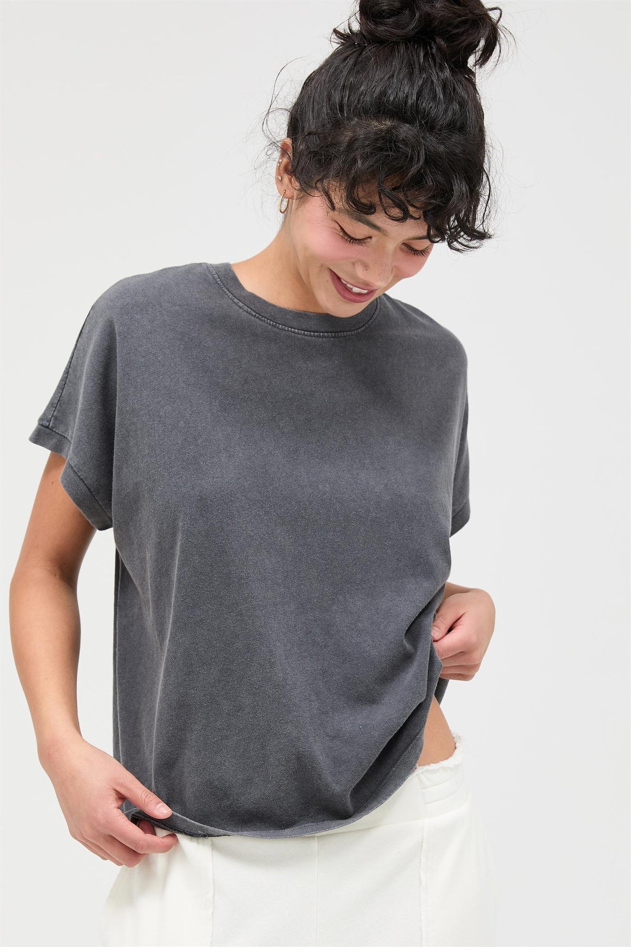 woman wearing a dark gray oversized t-shirt with rolled sleeves and a relaxed fit